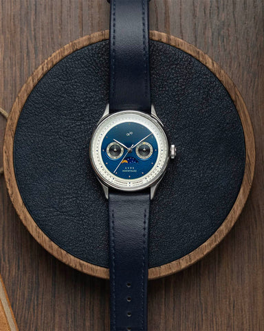 AV86 1968 Moonphase Watch with blue face and dark Blue strap on a wooden stand