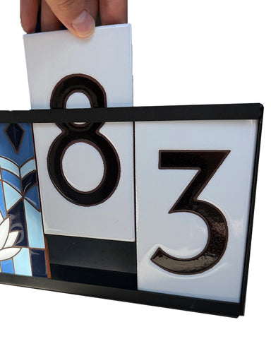Decorative house number sign with '83' on a white background